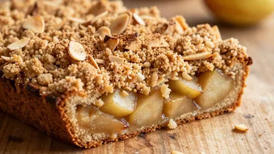 Apfel-Streuselkuchen mit Zimt und Mandeln auf Holztisch